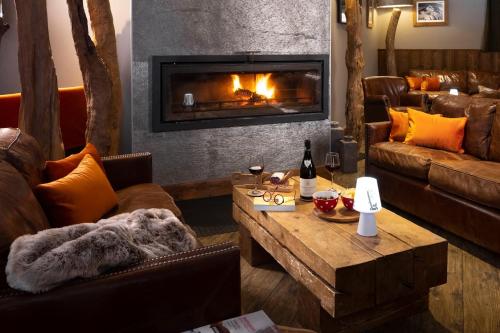 a living room with couches and a fireplace at Hôtel Ski Lodge - Chambres & Appartements - Village Montana in Val dʼIsère