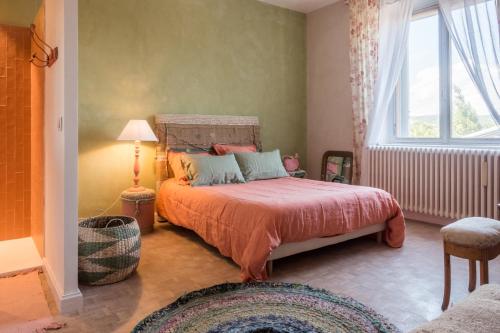 a bedroom with a bed and a window at Le Rucher des Arts in Alba-la-Romaine