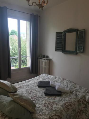une chambre avec un lit avec un miroir et une fenêtre dans l'établissement maison en pierre de taille, à Le Raincy