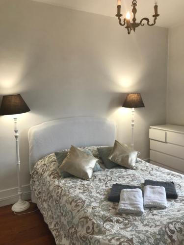 - une chambre avec un lit blanc et 2 lampes dans l'établissement maison en pierre de taille, à Le Raincy