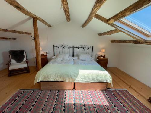 a bedroom with a bed and a chair and a rug at Casa Rural As Bodegas - Boal in Boal