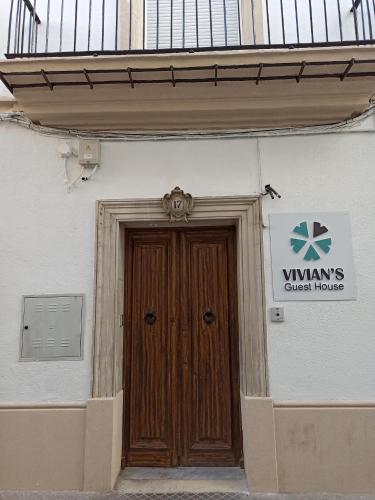 una porta di legno sul lato di un edificio di Vivian's Guest House a Jerez de la Frontera