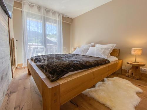 a bedroom with a bed and a large window at Appartement Jade Megève 2/4 personnes. in Megève