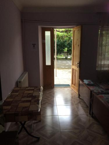 a living room with a table and a door to a yard at Giorgi's Homestay in Kutaisi