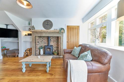 a living room with a couch and a fireplace at Host & Stay - Waterleap Cottage in Ovingham