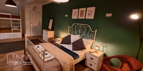 a bedroom with a bed and a green wall at Village Cascais Guest House in Cascais
