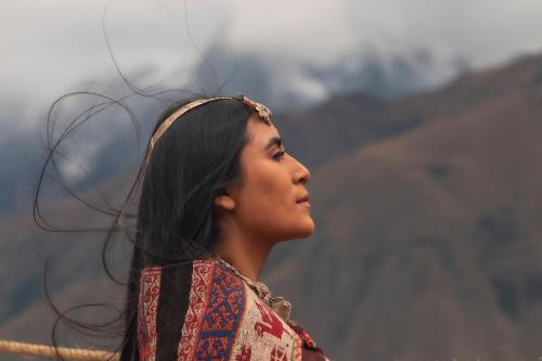 a woman standing in front of a mountain at Vertical Sky Suites in Ollantaytambo