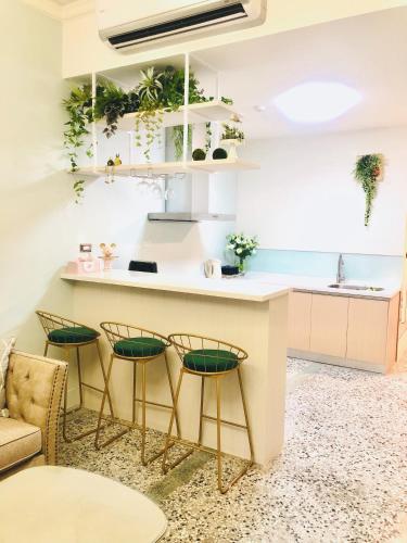 a kitchen with green chairs and a counter with a sink at 小院子4人至6人包棟民宿 in Taitung City