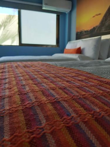 a bedroom with a bed with a colorful blanket at Hotel Boutique Mardeka in Orizaba