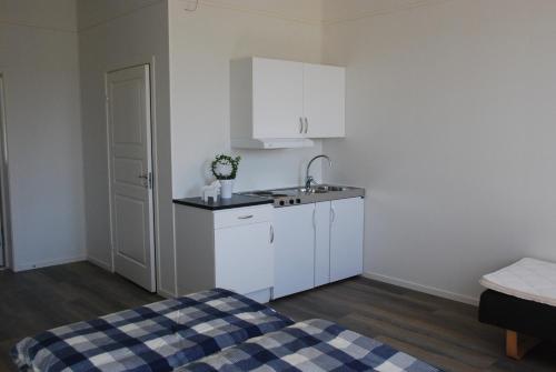una pequeña cocina con armarios blancos y fregadero en Kullan, en Rättvik