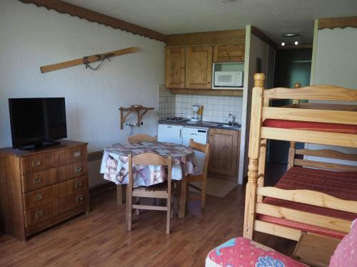 Il comprend une petite cuisine avec une table et des lits superposés. dans l'établissement travelski home classic - Résidence Grande Masse, aux Menuires