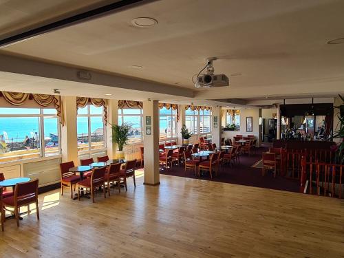 a restaurant with tables and chairs and a view of the ocean at Hotel Maria in Sandown