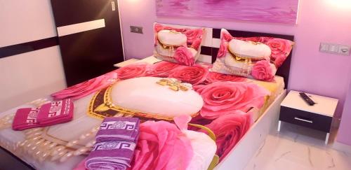 a bedroom with a bed with pink sheets and roses at Perfect Suites in Neos Marmaras