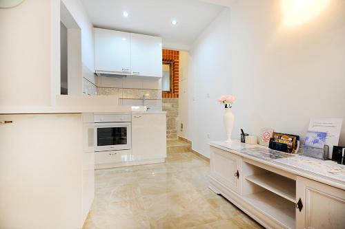 cocina con armarios blancos y encimera en Apartment Primera, en Zadar