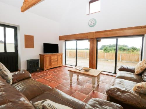 a living room with a couch and a table at Little Barn in Whissonsett