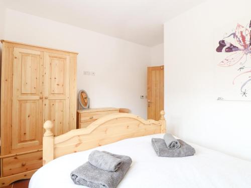 a bedroom with a bed with two towels on it at Little Barn in Whissonsett