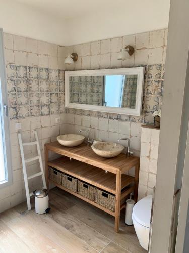 a bathroom with two sinks and a mirror at Maison d'Hôtes de Charme Le Clos de la Fontaine Piscine & SPA in Labastide-Marnhac