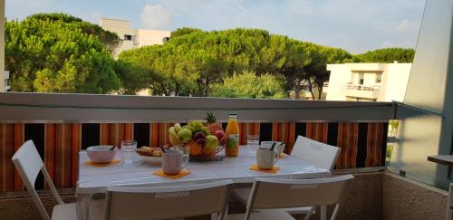 une table avec un bol de fruits sur un balcon dans l'établissement T2 dans une jolie résidence arborée de FRÉJUS, à Fréjus