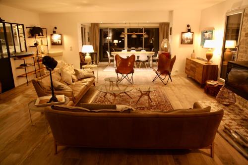 a living room with a couch and a table at Maison d'Hôtes de Charme Le Clos de la Fontaine Piscine & SPA in Labastide-Marnhac