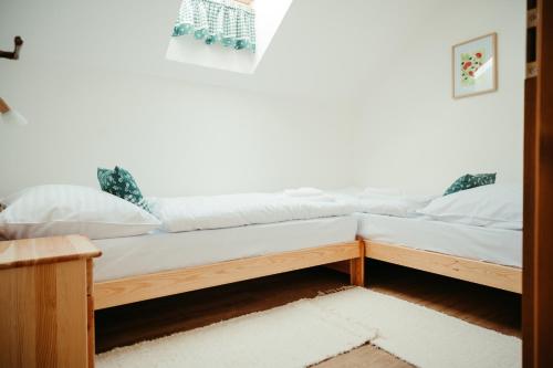 a bed in a room with white sheets and pillows at Penzion Stříbrník in Krásná