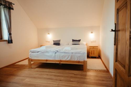 a bedroom with a bed with white sheets and pillows at Penzion Stříbrník in Krásná