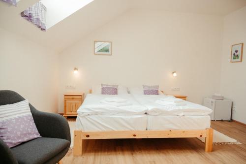 a bedroom with a bed and a chair at Penzion Stříbrník in Krásná