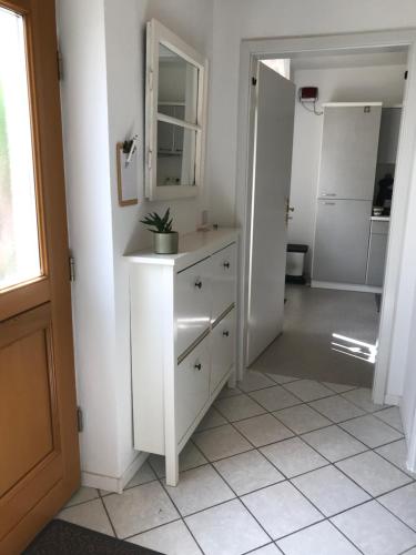 a white bathroom with a sink and a mirror at Ferienwohnung Nele in Waldesch