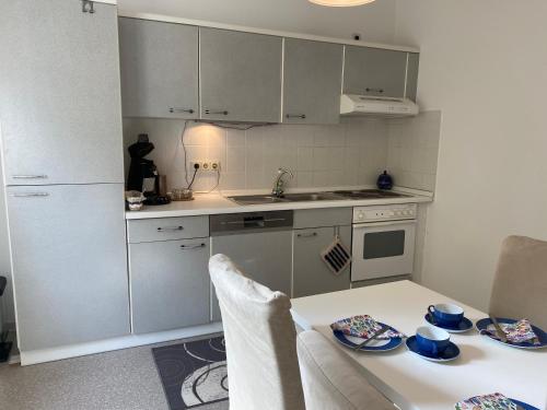 a kitchen with white cabinets and a table with dishes on it at Ferienwohnung Nele in Waldesch