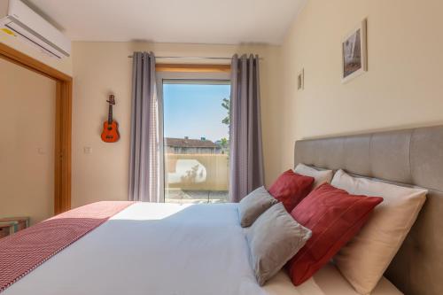 een slaapkamer met een bed en een raam met een gitaar bij Music Relaxing Apt with bikes, terrace & parking in Porto