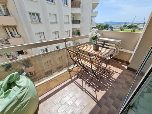 un balcon avec une table et des chaises sur un immeuble dans l'établissement GregBnb - T2 Pleine Ville - CLIMATISE - BALCON - 1, à Toulon
