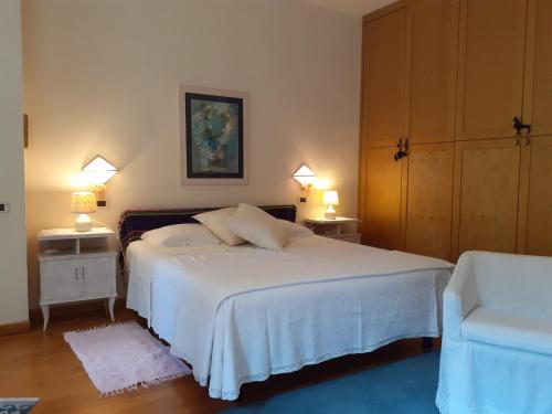 a bedroom with a white bed and two night stands at La Vittoria 10 – La Soglia della Val d’Orcia in Chianciano Terme