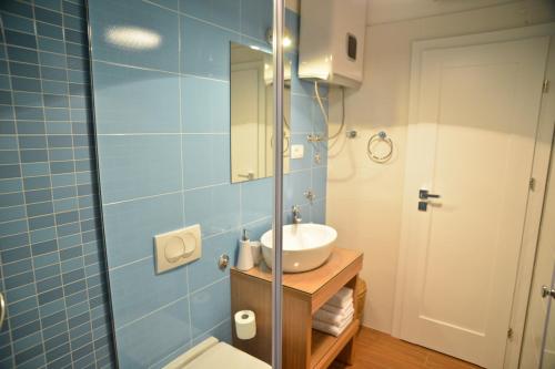 a blue tiled bathroom with a sink and a toilet at Nautical rooms Old town in Zadar