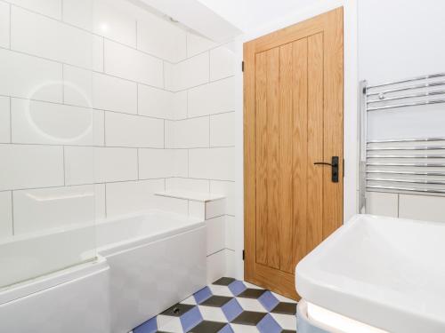 a bathroom with a toilet and a wooden door at Strawberry Stables in Bristol