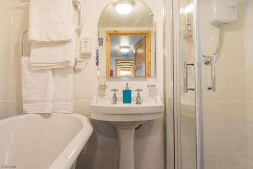 a white bathroom with a sink and a shower at Plumcot Halt by Bloom Stays in Canterbury