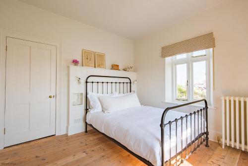 ein Schlafzimmer mit einem weißen Bett und einem Fenster in der Unterkunft East Cottage by Bloom Stays in Dungeness