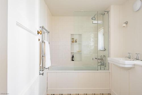 ein weißes Badezimmer mit Badewanne und Waschbecken in der Unterkunft East Cottage by Bloom Stays in Dungeness