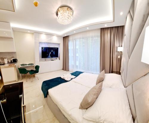 a bedroom with a large bed and a living room at Adonis Beach in Świnoujście