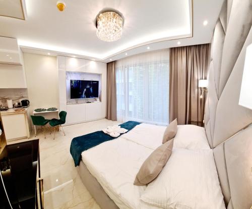 ein Schlafzimmer mit einem großen Bett und ein Wohnzimmer in der Unterkunft Adonis Beach in Świnoujście