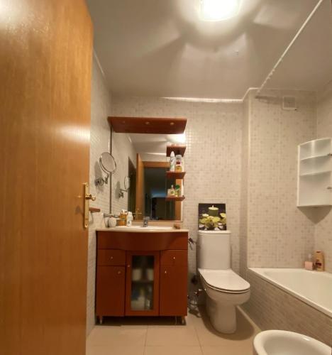 a bathroom with a toilet and a sink and a tub at Sitges Living Apartment in Sitges