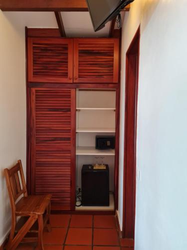 a room with a wooden closet with a chair at Chambre d'hotes "Villa Rayon Vert" in Deshaies
