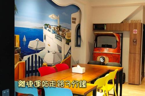 a dining room with a table and a rv mural at Go Home Homestay in Kaohsiung