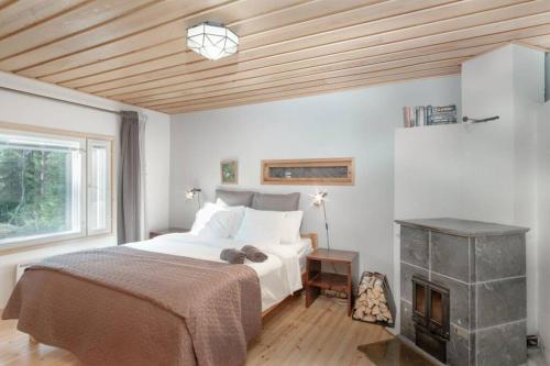 a bedroom with a large bed and a fireplace at Sirpa's Artistic Nuuksio Retreat with Heated Pool in Espoo