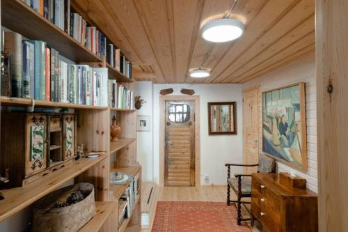 una habitación con estanterías de madera llenas de libros en Sirpa's Artistic Nuuksio Retreat with Heated Pool en Espoo