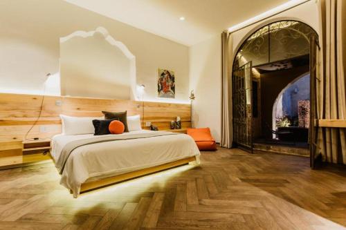 een slaapkamer met een groot bed en een gewelfde deur bij Tá Hotel de diseño in Querétaro
