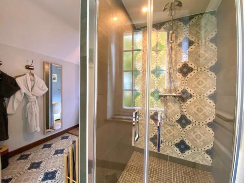 a shower with a glass door in a bathroom at La Maison de Manolie in Courcelles-Sapicourt