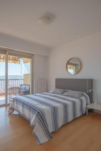 une chambre avec un grand lit et un balcon dans l'établissement 3 pièces vue mer et piscine quartier Parc Impérial, à Nice