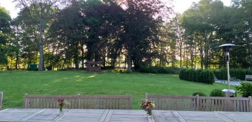 a park with a wooden fence and a field of grass at Herrenhaus Gut Neuruppersdorf in Timmendorfer Strand