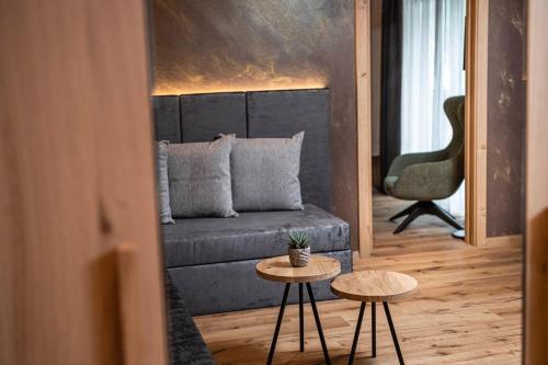a living room with a couch and two tables at Hotel Klostersepp in Chiusa