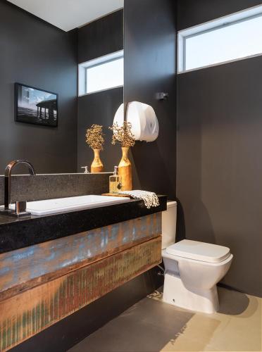 a bathroom with a sink and a toilet and a mirror at Pousada Noah in Capitólio