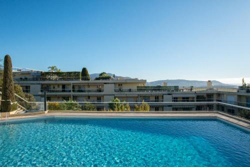 une grande piscine devant un immeuble dans l'établissement 3 pièces vue mer et piscine quartier Parc Impérial, à Nice